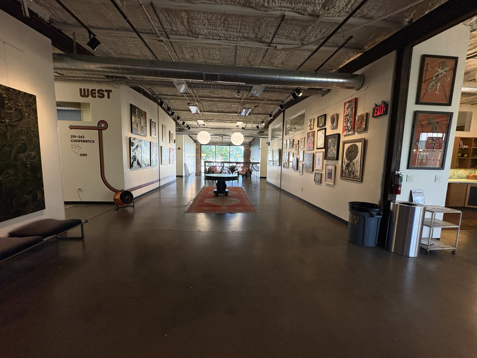 A long gallery corridor inside WOMPA with many framed artworks